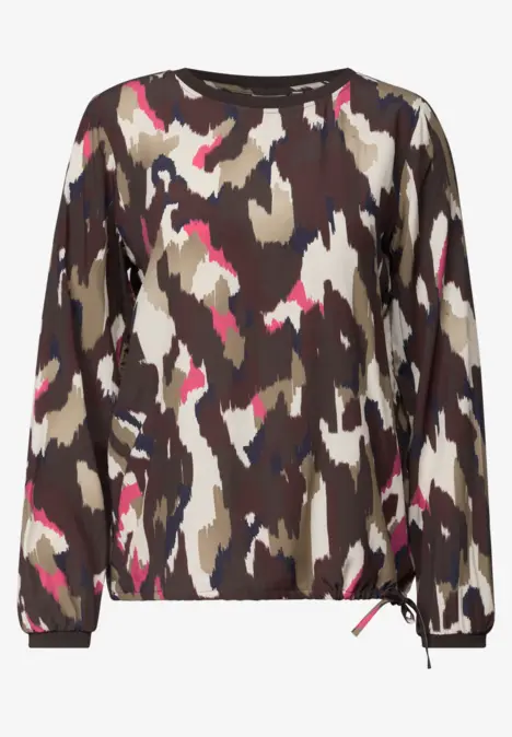 Pull à manches longues avec motif camouflage abstrait tons terre et touches de rose.