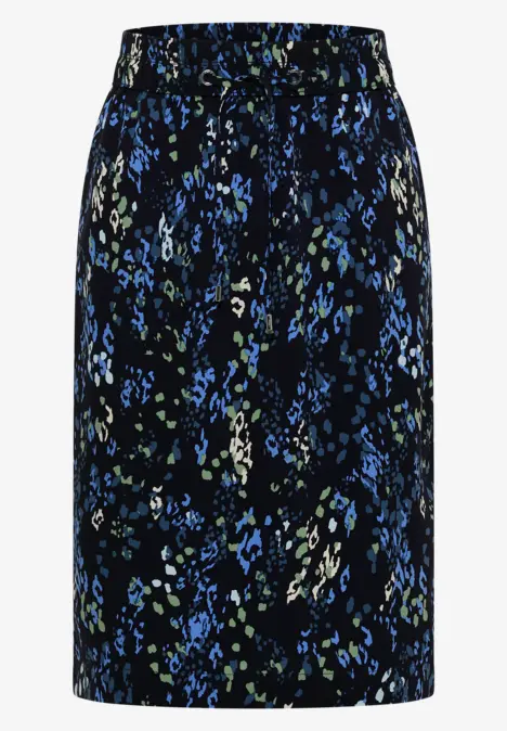 Jupe noire mi-longue à motif floral bleu et vert.