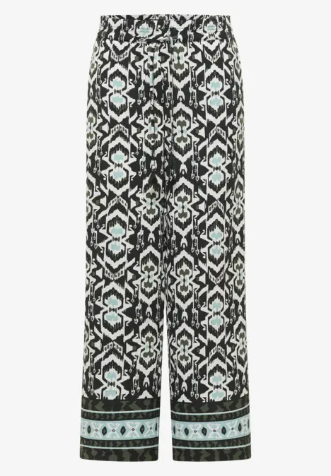 Schwarze Stoffhose mit Ethno-Muster und türkisfarbenen Bordüren.