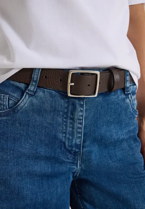 Blaue Jeanshose mit braunem Gürtel und weißem T-Shirt
