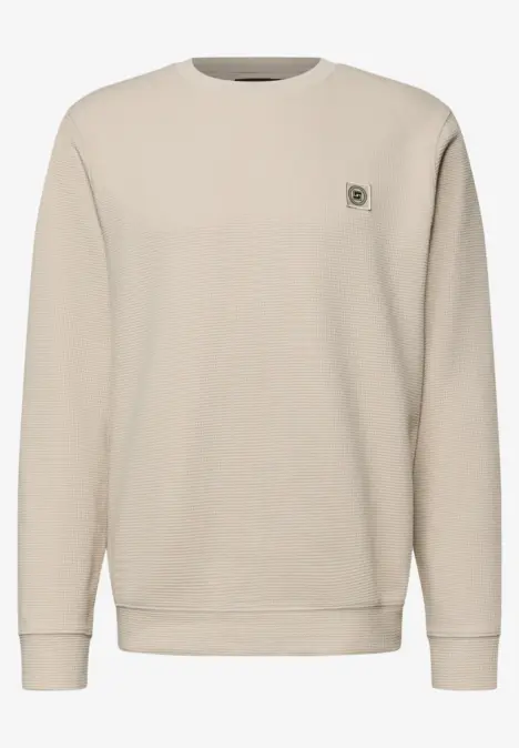 Beiger Pullover mit Rundhalsausschnitt und kleinem Emblem auf der Brust.